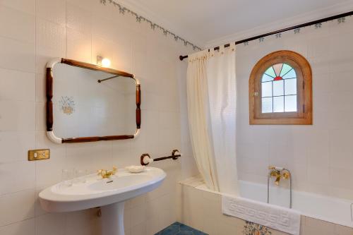 a white bathroom with a sink and a mirror at Vallespir in Port d'Alcudia