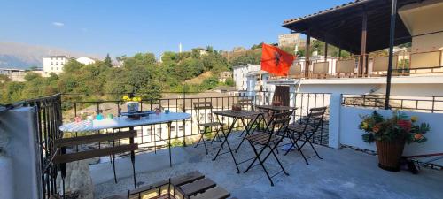 a balcony with a table and chairs on a building at Guest House Emily in Gjirokastër