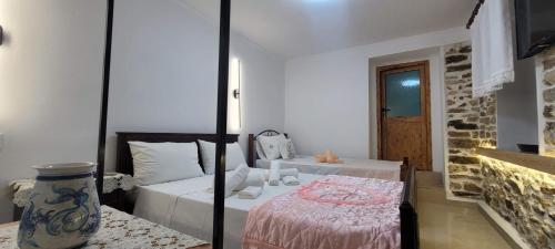 a bedroom with two beds and a vase at Guest House Emily in Gjirokastër