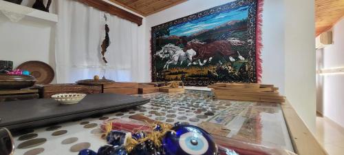 a room with a painting on the wall and a table at Guest House Emily in Gjirokastër