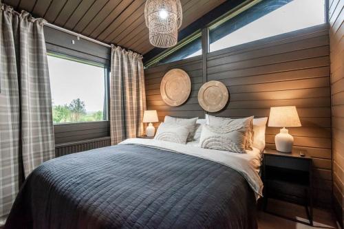 MiðdalurModern Summerhouse Views Outdoor Spaces Patio的一间带大床和窗户的卧室