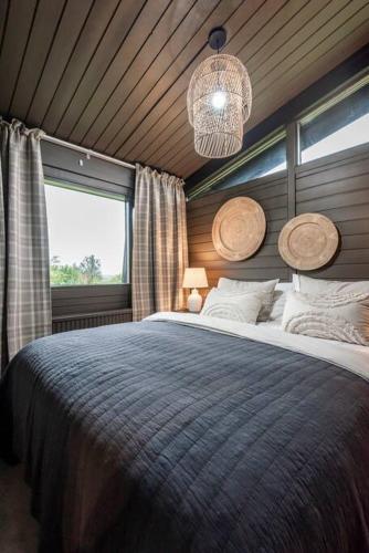 a bedroom with a large bed and a large window at Modern Summerhouse Views Outdoor Spaces Patio in Miðdalur