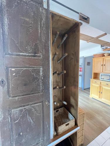 une porte en bois ouverte avec un panier dans une cuisine dans l'établissement Appartement 4 à 6 P proche télécabine et centre, à Champagny-en-Vanoise