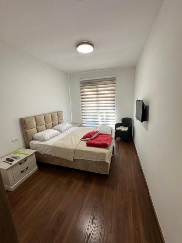 a bedroom with a large bed and a window at Sunrise apartment in Podgorica