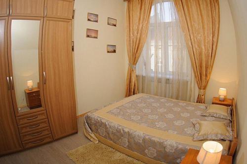 een slaapkamer met een bed en een groot raam bij Anna Apartments in Lviv