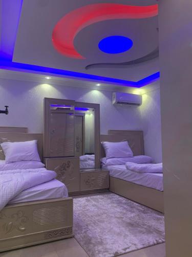 a room with two beds and a blue ceiling at شقة المهندسين in Cairo