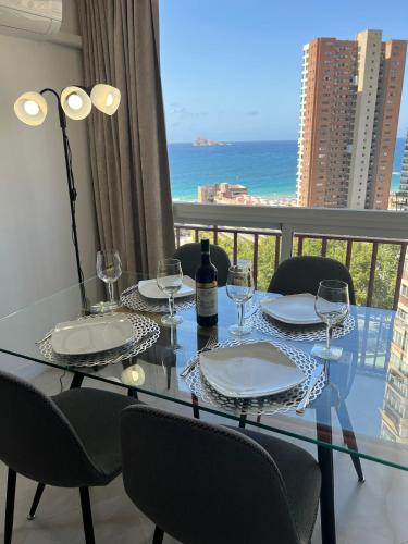 a dining table with wine glasses and a view of the ocean at BENILOVE en PLAYA in Benidorm
