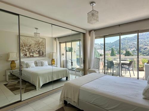 a bedroom with two beds and a glass wall at CANNES CROISETTE Sea & Sky in Cannes