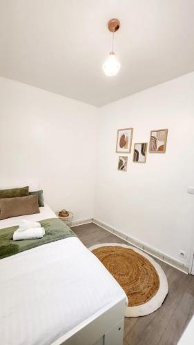 une chambre blanche avec un lit et un parquet dans l'établissement Appartement cosy situé dans un quartier calme, à Villejuif