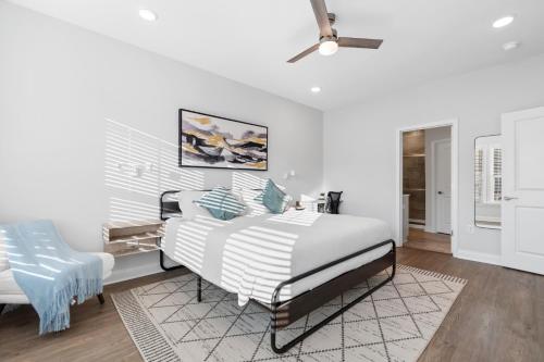Un dormitorio blanco con una cama y una silla azul. en Tee & Sea Paradise by myBeach Vacation Rentals, en Myrtle Beach