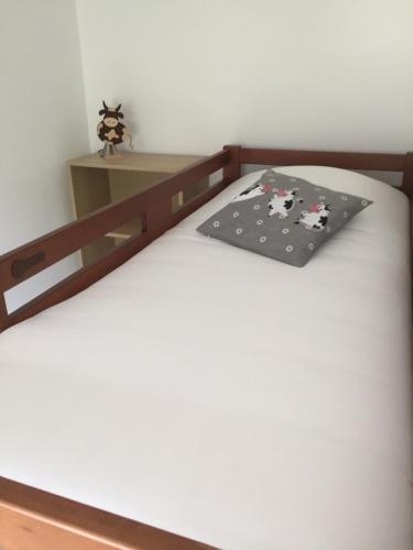 a bed with a pillow with cows on it at Chambres d'hôtes A la Fecht Nature et Bien-être in Sondernach
