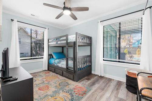 a bedroom with a bunk bed and two windows at Dog Friendly Home- Grill, Pool, Fire Pit by myBeach Vacation Rentals in Myrtle Beach