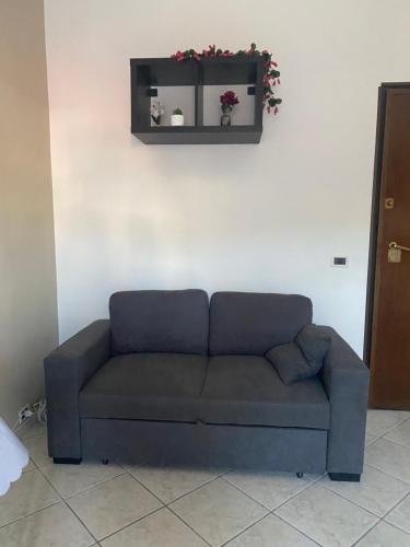 a blue couch in a room with a shelf on the wall at My Suite Fiuggi in Fiuggi