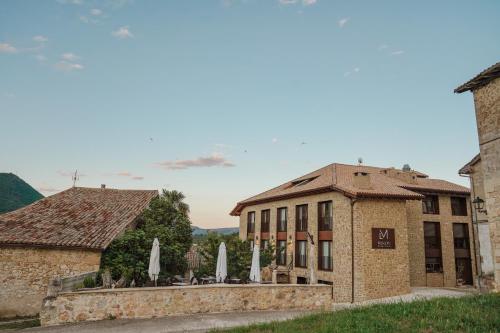 a building with umbrellas in front of it at Hotel Rural Milaleku in Ecala
