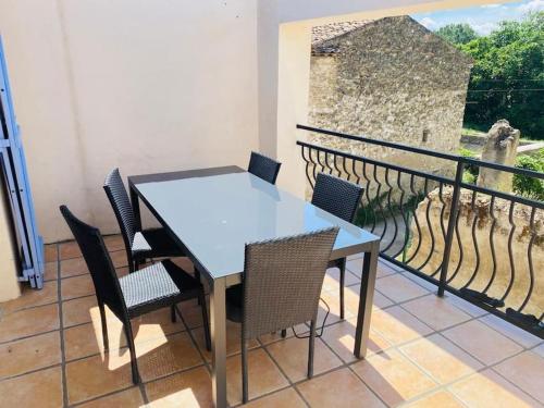d'une table et de chaises sur un balcon avec un mur. dans l'établissement Charmante maison de village, à Villelaure