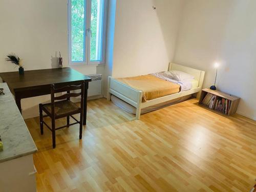 - une chambre avec un bureau, un lit, un bureau et une chaise dans l'établissement Charmante maison de village, à Villelaure