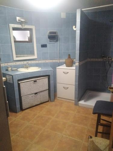 a blue bathroom with a sink and a mirror at La Cabaña de Piedra in Ruidera