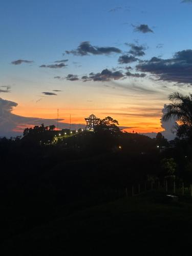 a sunset with a palm tree and the sky at Villa Jair Hotel in Filandia
