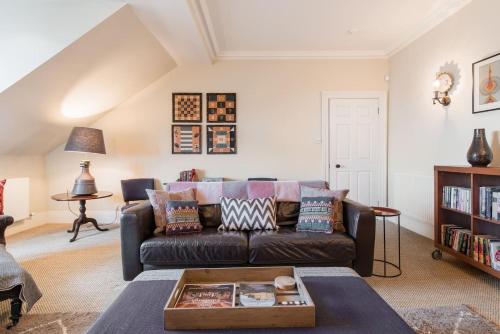 a living room with a couch and a table at Super Central - Georgian Double Upper Flat with Castle Views in New Town in Edinburgh