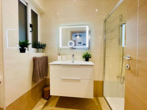 Un baño con lavabo y ducha de cristal. en 2BR Saint PAuls Bay Apartment By Holihomes, en St Paul's Bay