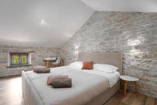 a bedroom with a large bed and a stone wall at Villa Treori in Orbani