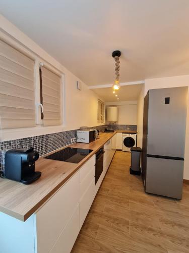  La cuisine est équipée de placards blancs et d'un réfrigérateur. dans l'établissement Happy Home, à Valenton