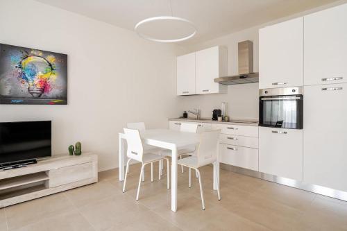 a white kitchen with a white table and chairs at Ca' Borsa II - Angolo nascosto nel cuore di Treviso in Treviso