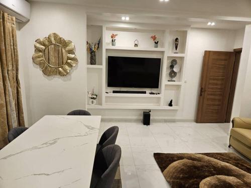 达喀尔Appartement F4 Cité Keur Gorgui,Dakar,Sénégal的配有电视、桌椅的客厅