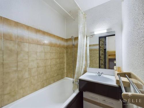 une salle de bain avec une baignoire, un lavabo et une douche dans l'établissement Studio cosy avec balcon, à 50m des pistes, 4 pers, au pied des commerces - FR-1-398-628, à Montvalezan