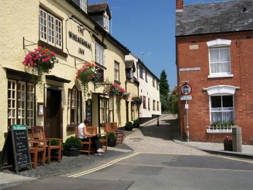 a man sitting at a table outside of a building at Frog Cottage, Ludlow - a charming townhouse for 4 in Ludlow