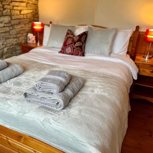 a bed with towels and pillows on top of it at Frog Cottage, Ludlow - a charming townhouse for 4 in Ludlow