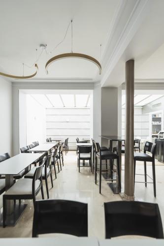 une salle à manger avec tables et chaises et un lustre dans l'établissement Hotel Corona -Rodier-, à Paris