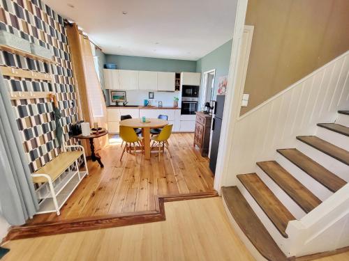 une cuisine et une salle à manger avec une table et un escalier dans l'établissement 726-Belle maison bretonne, centre-ville, port et p, à Audierne