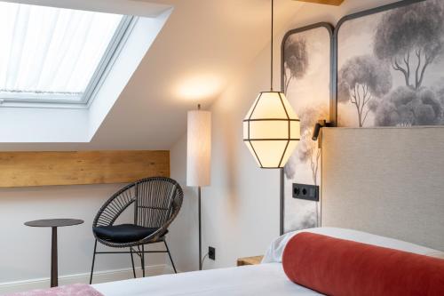a bedroom with a bed and a chair and a window at Os Cantís in Cedeira
