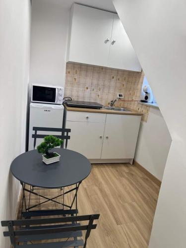 a small kitchen with a table and a sink at Lacasadelrelax in Monreale