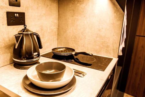 a kitchen counter with a tea kettle and plates on it at Modern 1-Bed Studio 4D Close to Royal Infirmary & DMU in Leicester