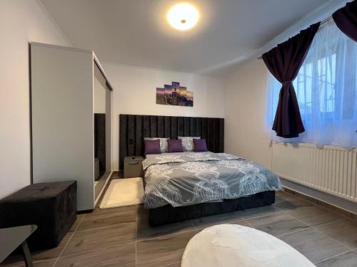 a bedroom with a bed and a large window at Temple of the Sights in Buşteni