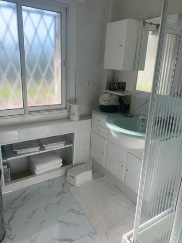 une salle de bain blanche avec un lavabo et un miroir dans l'établissement Sea view panorama quiet Europe appartment, au Cannet