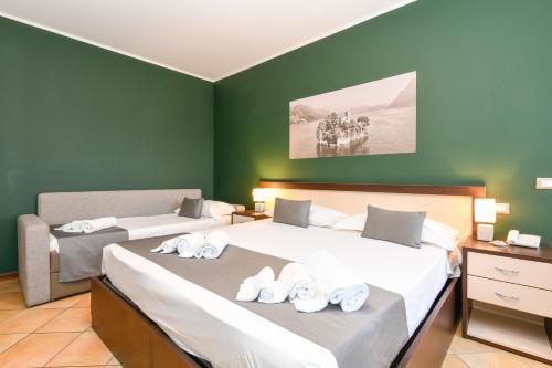 two beds in a room with green walls at Albergo Locanda Primavera in Rodengo Saiano
