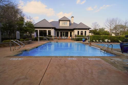 a house with a swimming pool in front of a house at Charming 2 bedroom, 2 bath apartment in Austin