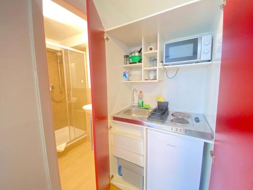 a small kitchen with a sink and a microwave at LUX Apartments in Mörfelden-Walldorf