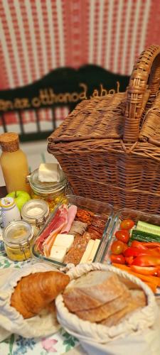 a table with a tray of food and a basket of food at Lassu Tanya Vendégház in Nagykőrös
