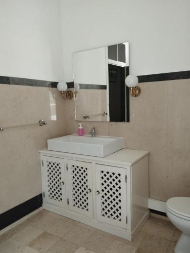 a bathroom with a white sink and a mirror at Tapada Nacional de Mafra in Mafra