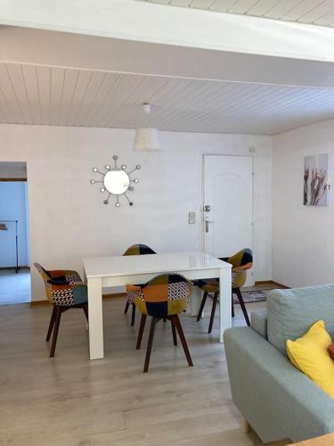 un salon avec une table et des chaises blanches dans l'établissement Appartement Cosy avec fibre très bien équipé, à Briare