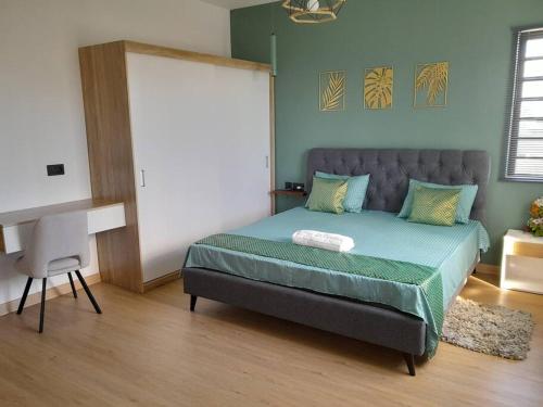 a bedroom with a bed and a desk in it at Villa Le Pendula in Grand Baie