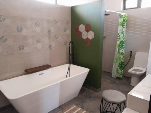 a bathroom with a large tub and a toilet at Villa Le Pendula in Grand Baie
