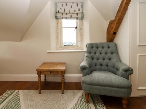 a living room with a chair and a table at Hammonds Farmhouse in Stroud