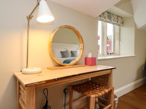 a dressing table with a mirror and a stool at Hammonds Farmhouse in Stroud