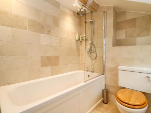 a bathroom with a tub and a toilet and a shower at Hammonds Farmhouse in Stroud