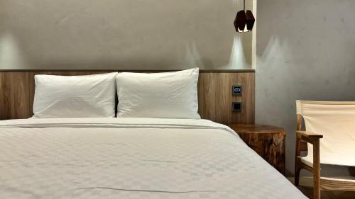 a bed with white sheets and pillows in a room at Hotel Initial-Tainan in Tainan